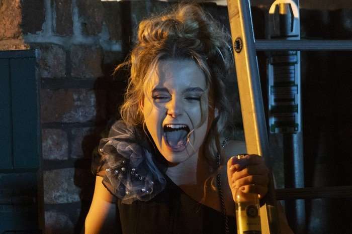 Betsy, stood beside some scaffolding, screams in a scene from Coronation Street