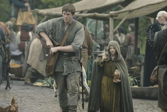 Peter Claffey as Dunk and Dexter Sol Ansell as Egg in A Knight of the Seven Kingdoms, walking through a busy medieval market