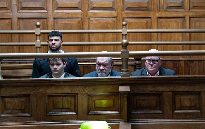 Bear, Paddy and Dylan sit in a courtroom in Emmerdale