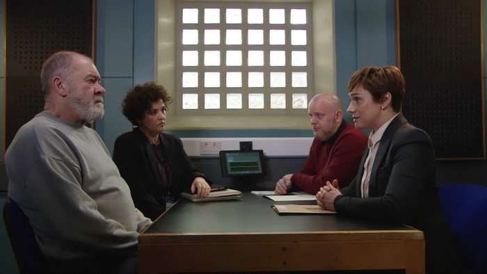 DS Walsh and a colleague sit opposite Bear Wolf and his solicitor in a police interview room in a scene from Emmerdale