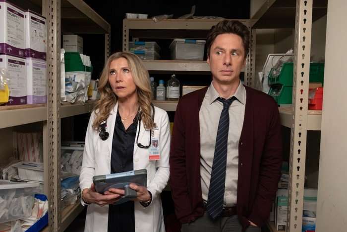 Sarah Chalke and Zach Braff star in Scrubs season 10; in this scene, Elliot and JD are stood in a storage cupboard, looking awkward