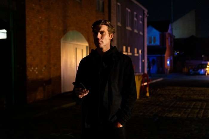 Theo stands in a darkened street in Coronation Street