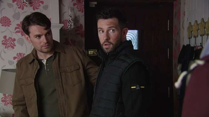Ross and Mack look shifty in a scene from Emmerdale