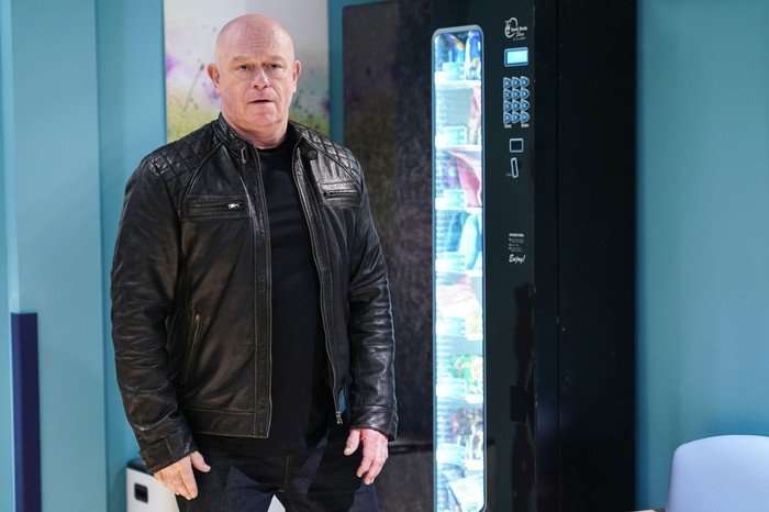 An uneasy Grant standing next to a hospital vending machine in EastEnders