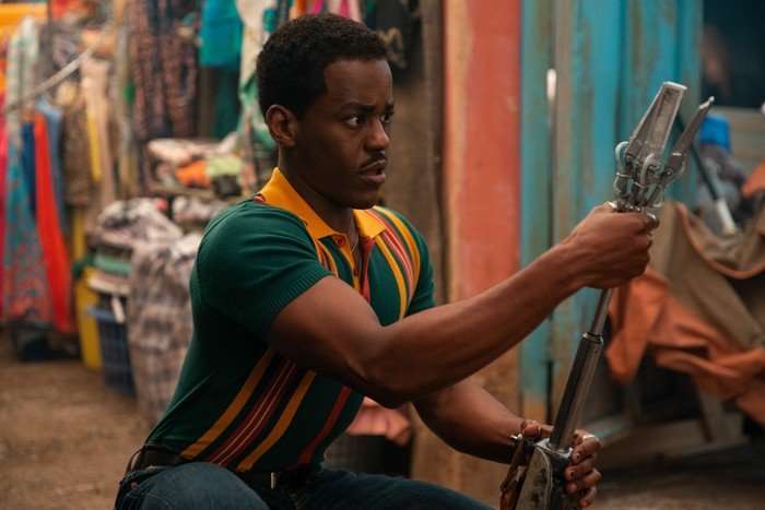 Ncuti Gatwa as the Doctor in Doctor Who episode The Story and the Engine. He's dressed in a stripey shirt and is holding the Vindicator tool.