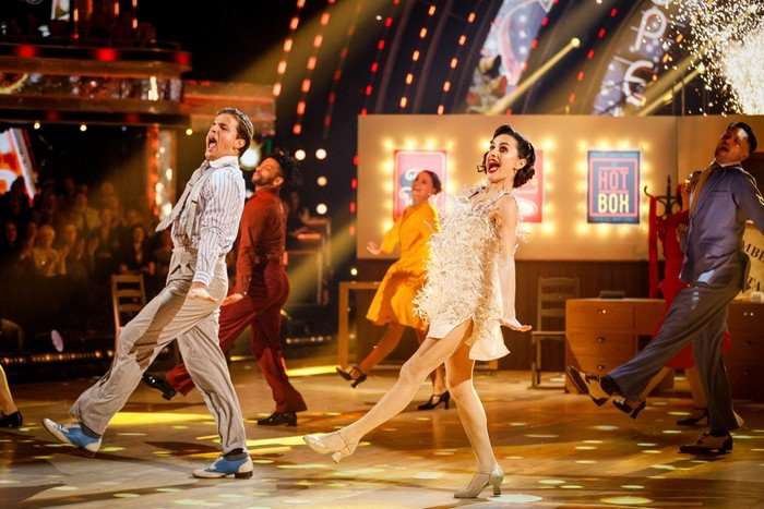 Nikita Kuzmin and Amber Davies in a dance hold, with wide smiles.