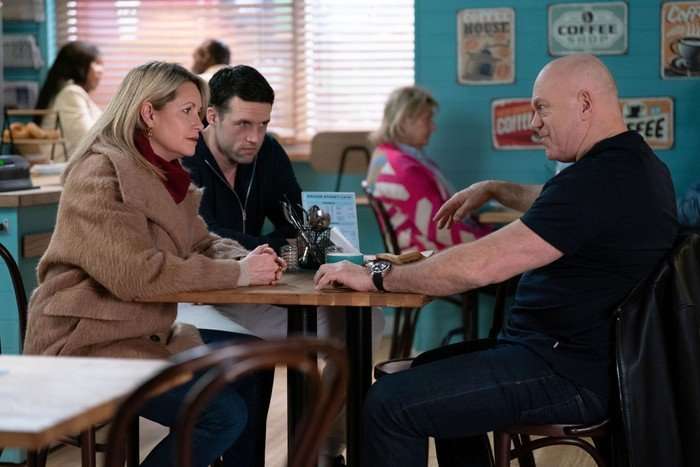Grant chats to Sam and Mark in the caff in a scene from EastEnders