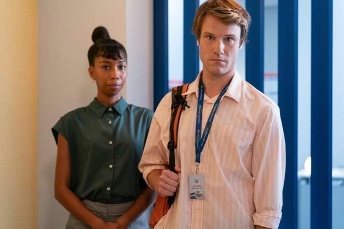 Nicole Sadie Sawyerr and Hugh Skinner star in Twenty Twenty Six; their characters are stood next to each other in an office