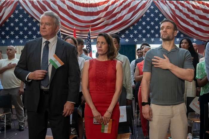 Hugh Bonneville, Jimena Larraguivel and Nick Blood star in Twenty Twenty Six; they are stood in a room decorated with the flag of the United States and looking somewhat awkward