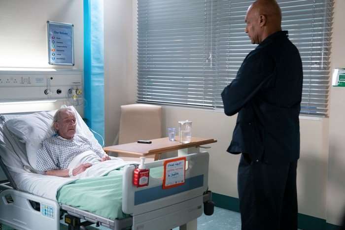 George stands at the foot of Eddie's bed in EastEnders