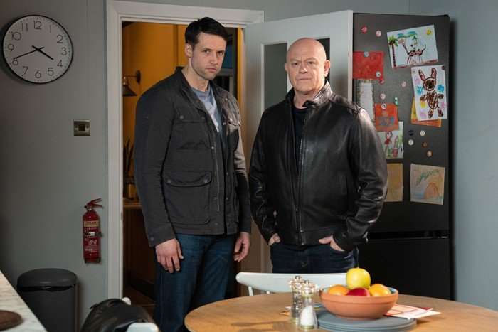 Mark and Grant stood in Phil's kitchen in a scene from EastEnders