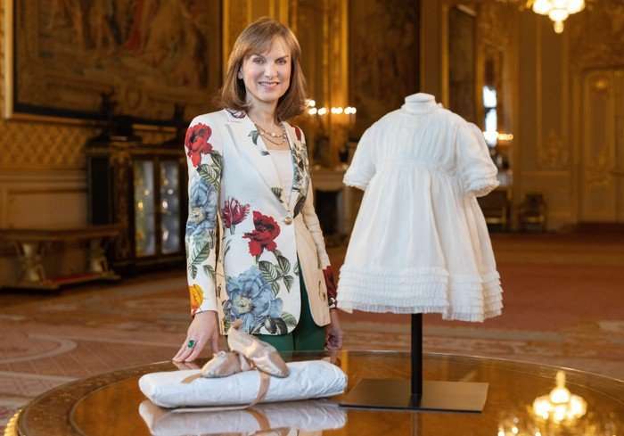 Fiona Bruce with the delicate baby dress and tiny ballet shoes once worn by Queen Elizabeth.