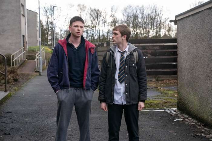 Stuart Campbell as Young Ruben and Mitchell Robertson as Young Niall in Half Man, stood next to each other. Ruben is wearing casual clothes while Niall is wearing school uniform.