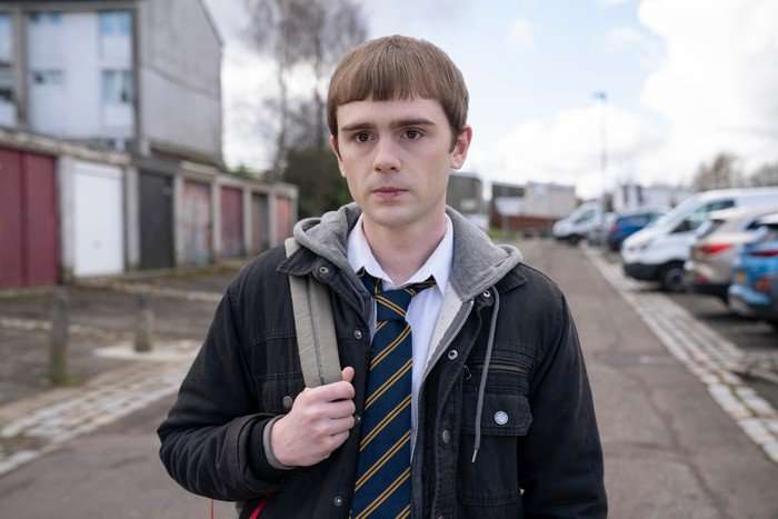Young Niall (MITCHELL ROBERTSON) in his school uniform in a block of flats