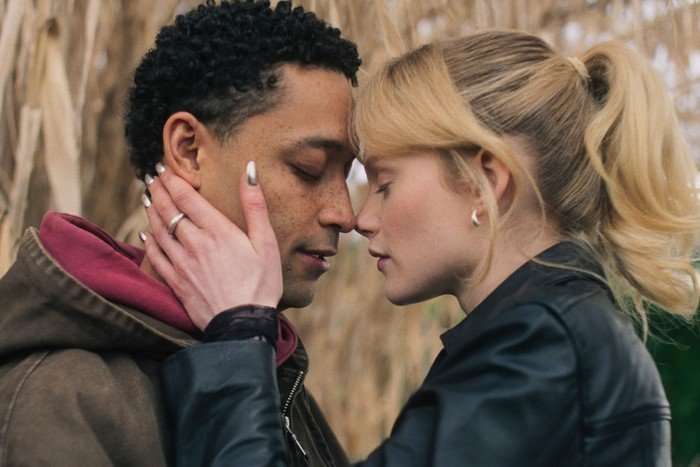 Ben Coyle-Larner as Arran and Emma Laird as Shannon in Mint. They are stood outside, have their heads pressed together and their eyes closed. Shannon has her hand on Ben's face.