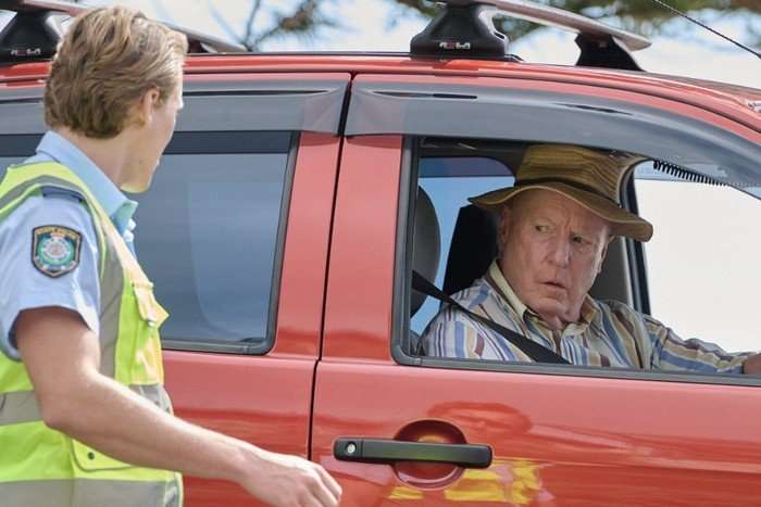 Alf Stewart driving a red car in Home and Away