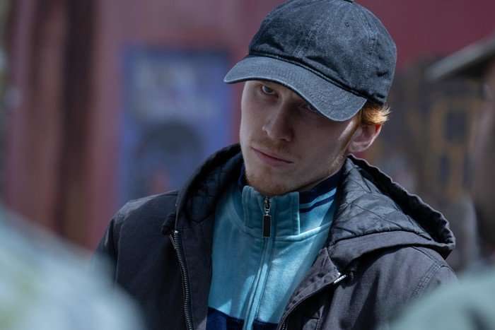 Luther Ford looking wearing a cap and looking ahead with an angry expression.