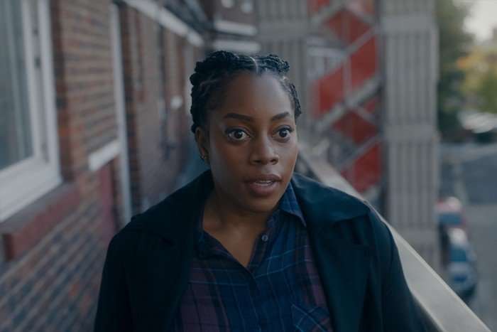 Dionne Brown in Criminal Record, stood outside, wearing a blue top and black jacket.