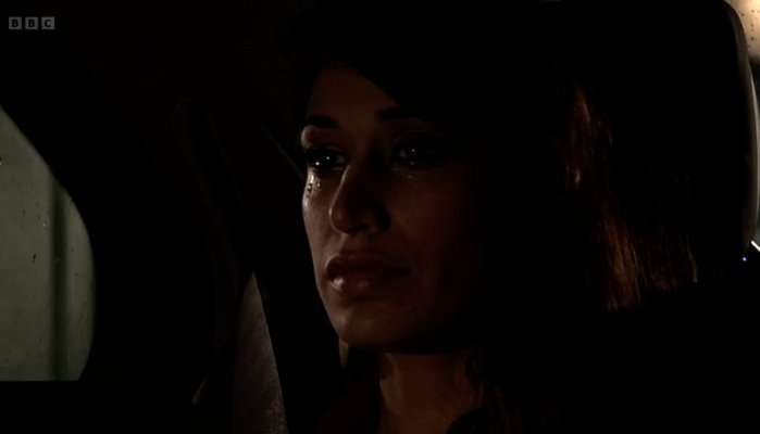 Amira Masood in the back of a car at night in EastEnders.