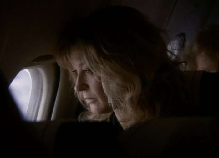 Gillian Taylforth as Kathy Mitchell looks out of an airplane window in a scene from EastEnders.