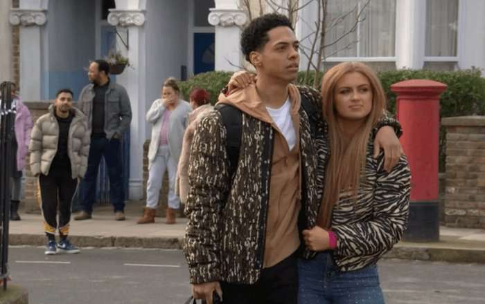 Zack Morris as Keegan Butcher-Baker and Maisie Smith as Tiffany Butcher-Baker stand in the street in EastEnders.