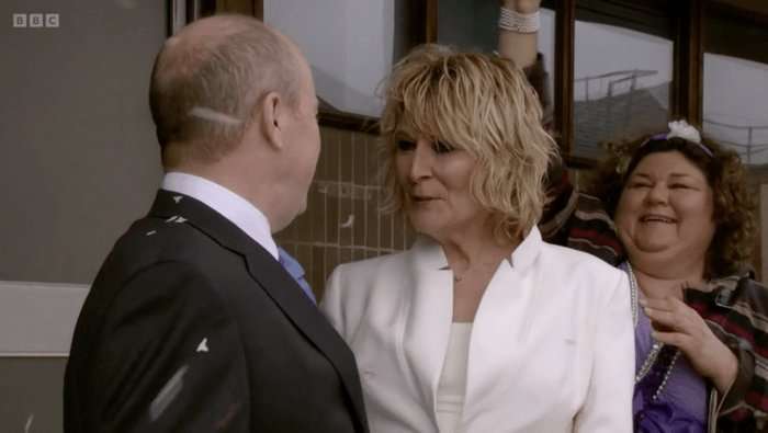 Steve McFadden as Phil Mitchell with Linda Henry as Shirley Carter in a bridal suit in EastEnders.