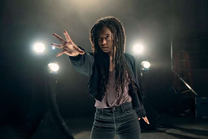 Jaz Sinclair as Marie Moreau in Gen V, surrounded by spotlights and holding her hand out.