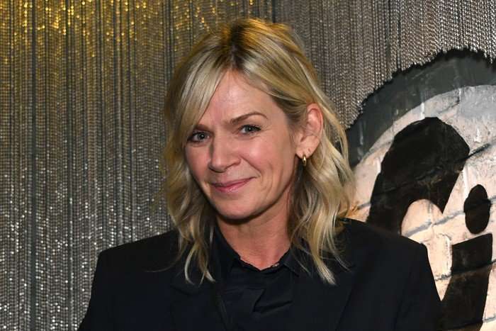 Zoe Ball smiling ahead, wearing a black outfit.