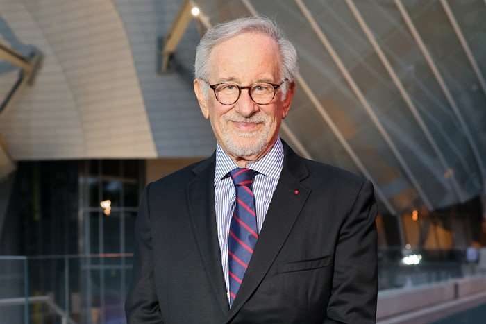 Steven Spielberg in a suit with a blue and red tie