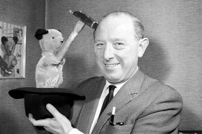 Sooty hitting Harry Corbett over the head with a small hammer.