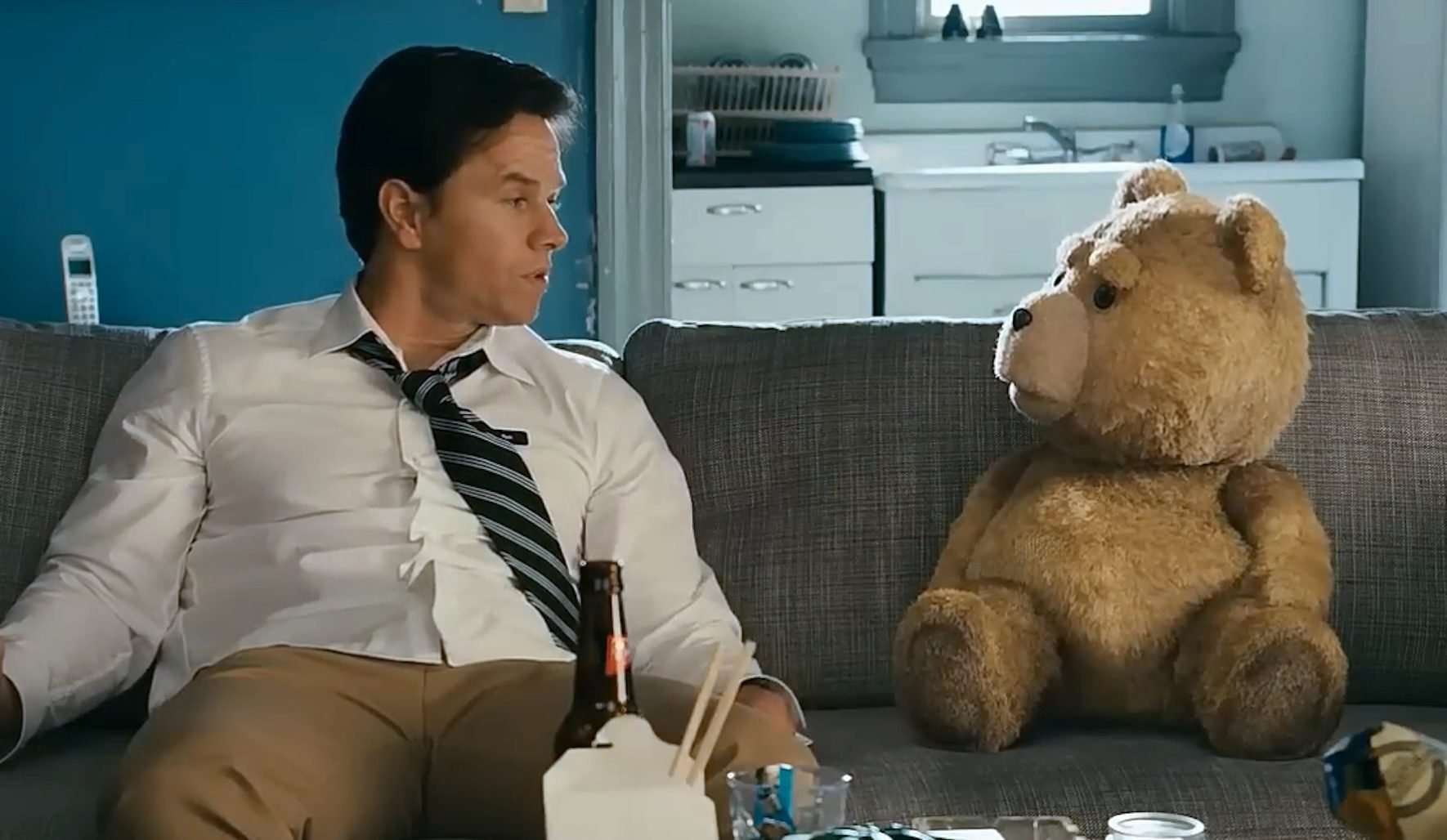 John (Mark Wahlberg) and Ted sitting on a couch in the 2012 film Ted.