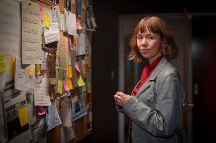 Anna Maxwell Martin as Lucy Betts-Taylor in Ludwig, stood by a board with post-its all over it.