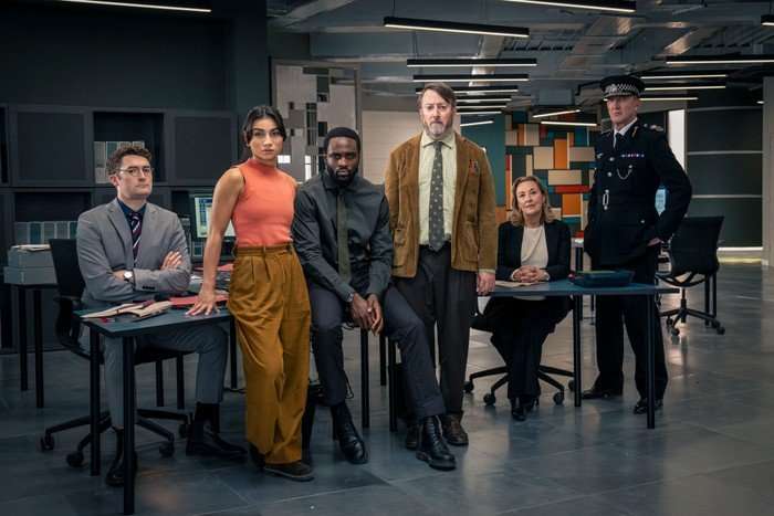 Ben Ashenden as DS Ethan Cole, Rumi Sutton as DC Caitlin Sullivan, Dipo Ola as DI Russell Carter, David Mitchell as John ‘Ludwig’ Taylor, Dorothy Atkinson as DCS Carol Shaw and Ralph Ineson as Chief Constable Ziegler in Ludwig, stood sat and leaning in a police office.