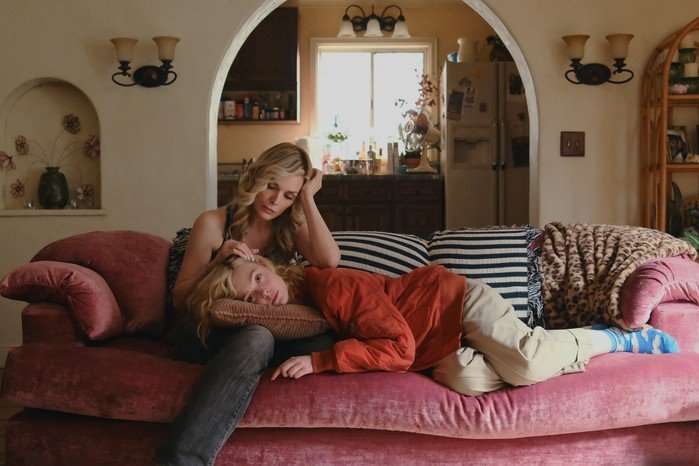 Michelle Pfeiffer and Elle Fanning Michelle Pfeiffer and Elle Fanning sit on a sofa. Michelle is stroking Elle's hair as she lies on her lap