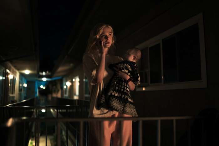 Elle Fanning in Margo’s Got Money Troubles Elle Fanning in Margo’s Got Money Troubles, standing on a balcony and holding a baby.