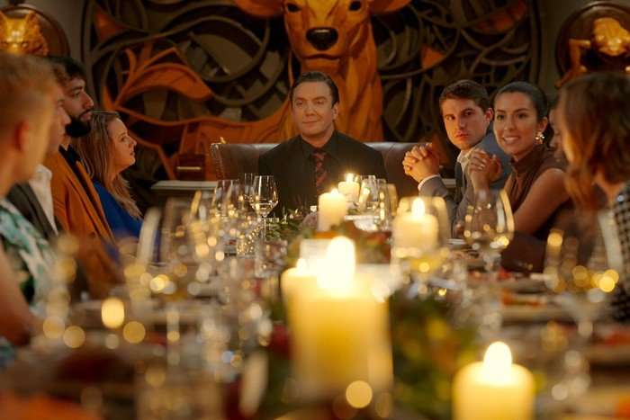 Tarek Ahmed, Lauren Gierth, Peter Serafinowicz, Kevin Moranz and Natalie Noisom all sat around a large dinner table looking at one another with smiles.