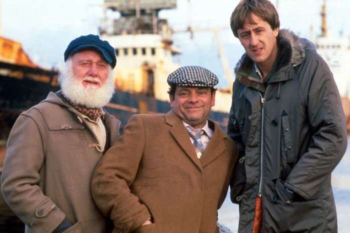 Buster Merryfield as Uncle Albert, David Jason as Derek 'Del Boy' Trotter and Nicholas Lyndhurst as Rodney Trotter in Only Fools and Horses. They are stood together with a large boat in the background.