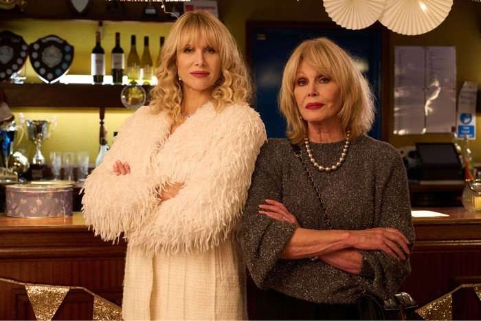Lucy Punch and Joanna Lumley stood next to each other, smiling, with their arms folded.
