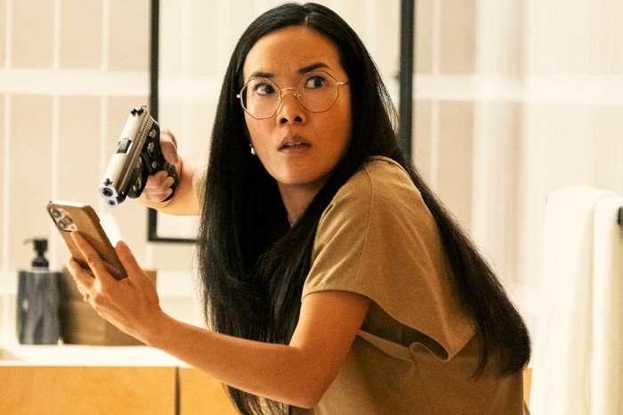 Amy pointing a handgun at her phone with an angry expression on her face