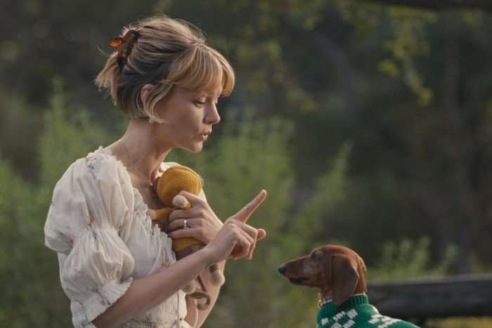 Carey Mulligan plays Lindsay in Beef season 2; she is seen here outdoors, holding a dog toy and issuing an instruction to a small dachshund