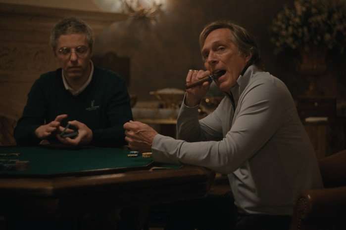 William Fichtner plays Troy in Beef season 2; he is sat at a poker table, smoking a cigar and looking over at someone across from him
