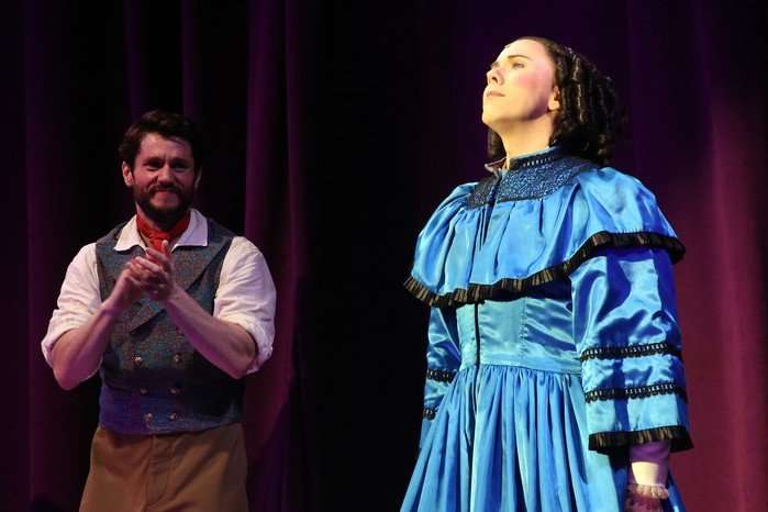Cole Escola as Mary Todd Lincoln prepares to bow in the spotlight as fellow cast members clap