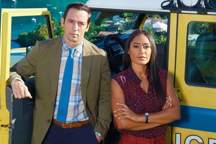 Neville and Florence standing in front of a police vehicle