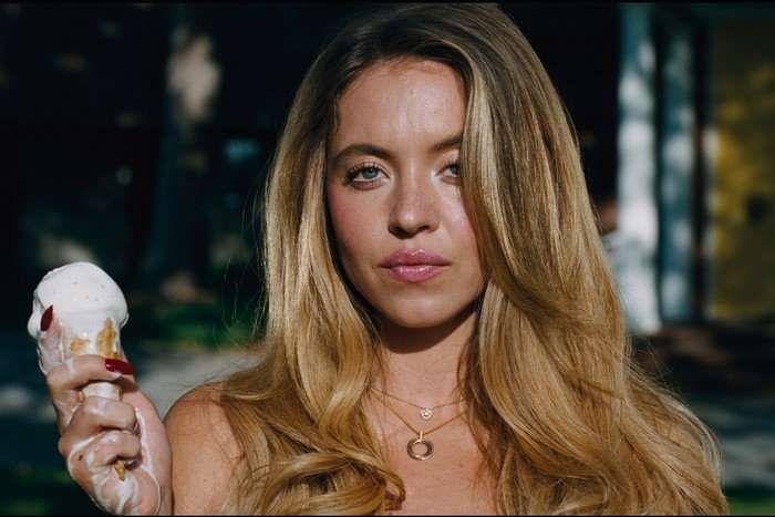 Sydney Sweeney standing in the sunlight, holding an ice cream.