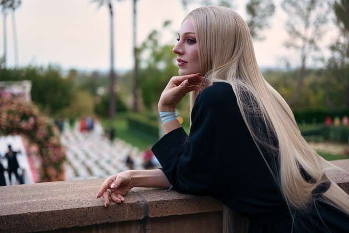 Hunter Schafer as Jules Vaughn in Euphoria season 3. in a black blazer leant on a ledge.