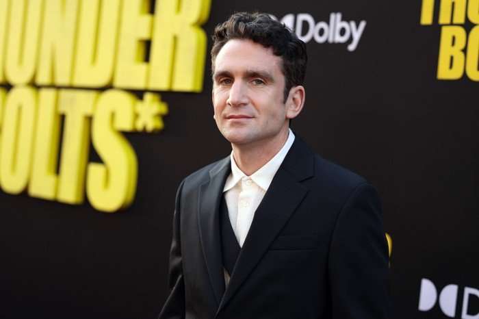 Jake Schreier photographed wearing a black suit and white shirt at the Thunderbolts* premiere