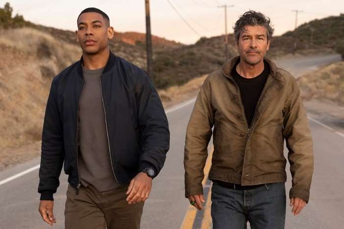 Aaron Pierre and Kyle Chandler star in Lanterns; seen here as John Stewart and Hal Jordan, wearing civilian clothing and walking down a rural road