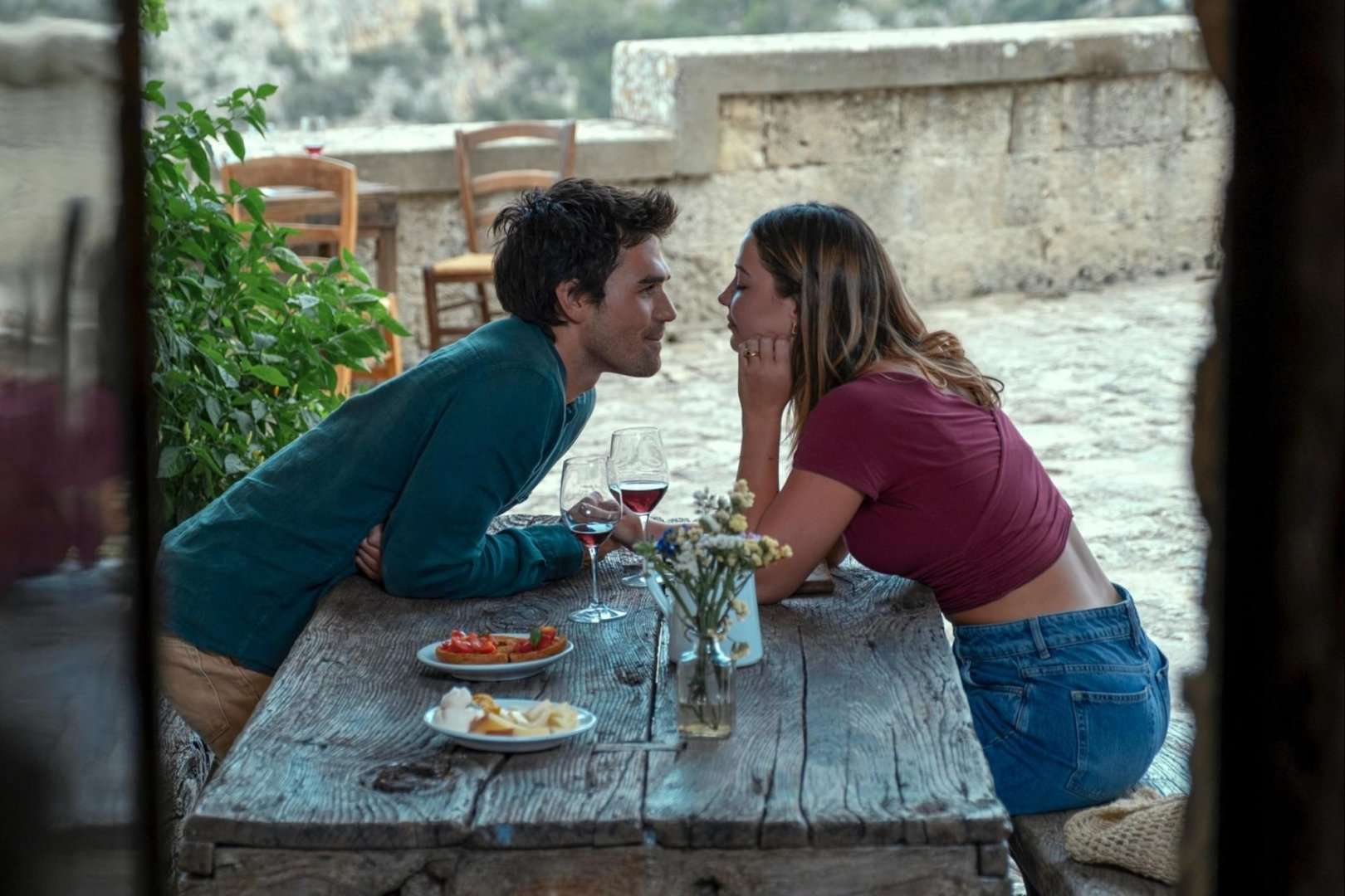 A man and woman sit at a table and stare.