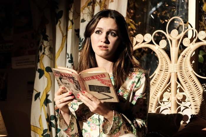 Maude Apatow reading a book on-stageas Lexi Howard in Euphoria season two