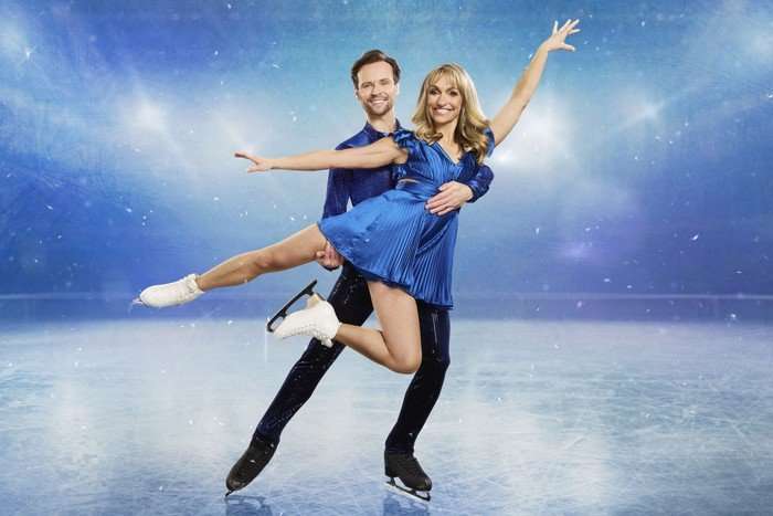 Mark Hanretty holding Michaela Strachan with both hands from behind as Michaela stretches her arms and legs outwards.